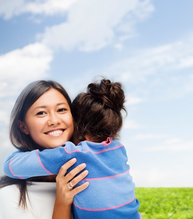 family, children and happy people concept - hugging mother and daughterの写真素材