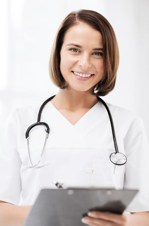 healthcare and medical concept - female doctor with stethoscope writing prescriptionの写真素材