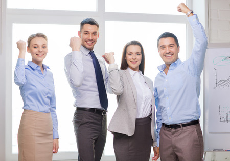 business, office, success and victory concept - happy business team celebrating victory in officeの写真素材
