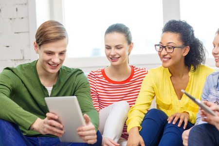 education and technology concept - smiling students with tablet pc computer at home
