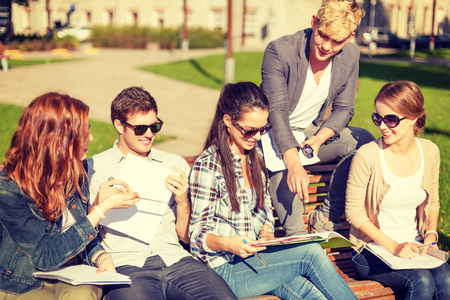 summer holidays, education, campus and teenage concept - group of students or teenagers with books, notebooks, files and foldersの写真素材