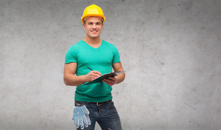 repair, construction and maintenance concept - smiling man in helmet with clipboard