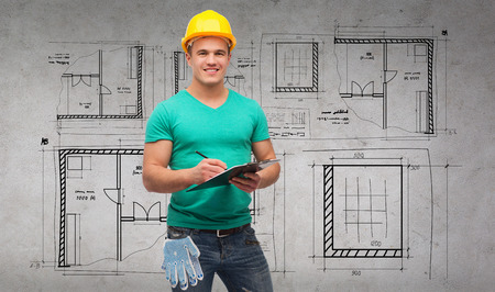 repair, construction and maintenance concept - smiling man in helmet with clipboard