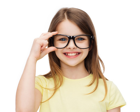education, school and vision concept - smiling cute little girl in black eyeglassesの写真素材