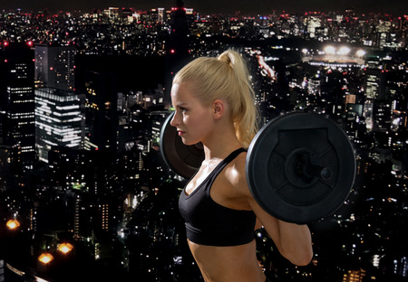 fitness, sport and dieting concept - sporty woman exercising with barbellの写真素材