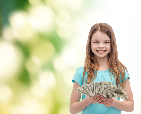 money, finances and people concept - smiling little girl with dollar cash moneyの写真素材