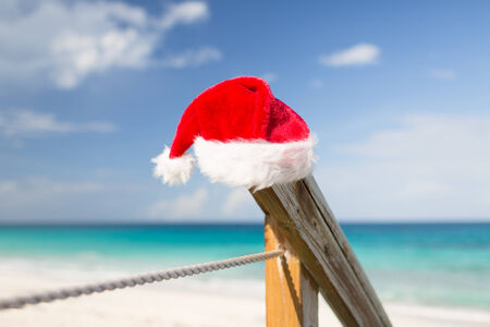 beach, summer, vacations, christmas and sea concept - close up of santa helper hat on beachの写真素材
