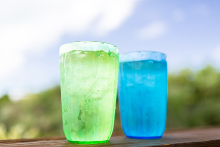 summer, drinks and holidays concept - close up of two glasses with cold water over nature backgroundの写真素材
