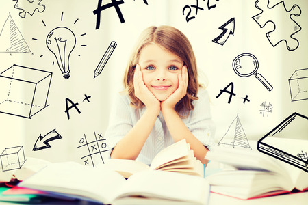 education and school concept - little student girl studying and reading books at schoolの写真素材