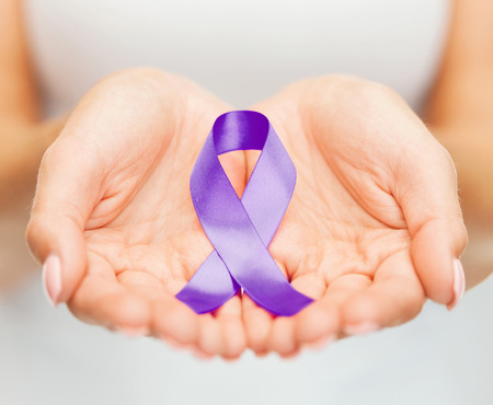 healthcare and social problems concept - womans hands holding purple domestic violence awareness ribbon