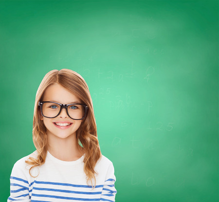 education, school and vision concept - smiling cute little girl with black eyeglasses