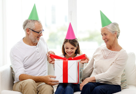 family, generation, holidays and people concept - smiling grandfather, granddaughter and grandmother...