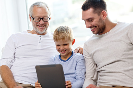 family, generation, technology and people concept - smiling father, son and grandfather sitting on...