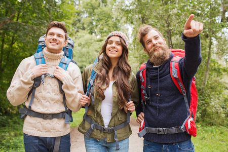 adventure, travel, tourism, hike and people concept - group of smiling friends with backpacks outdoorsの写真素材