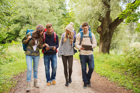 adventure, travel, tourism, hike and people concept - group of smiling friends with backpacks and...