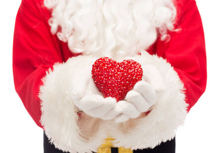 christmas, holidays, love, charity and people concept - close up of santa claus with heart shape decorationの写真素材