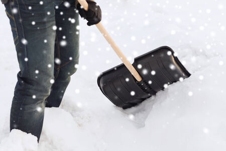 closeup of man digging snow with shovelの写真素材