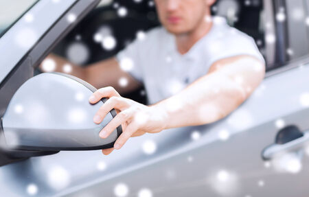 transportation, people and vehicle concept - close up of man adjusting car sideview mirror