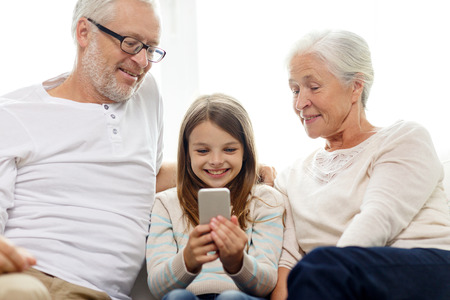 family, generation, technology and people concept - smiling grandfather, granddaughter and...