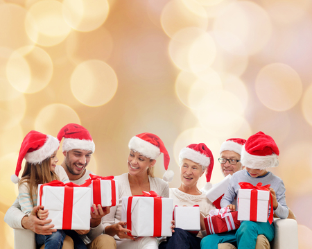 family, happiness, generation, holidays and people concept - happy family in santa helper hats with...