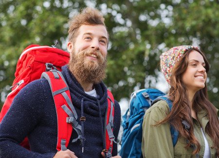 adventure, travel, tourism, hike and people concept - group of smiling friends walking with backpacksの写真素材