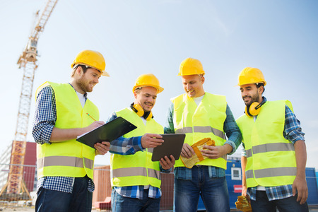 business, building, teamwork, technology and people concept - group of smiling builders in hardhats...