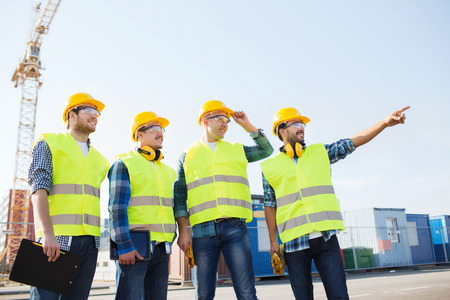 business, building, teamwork, technology and people concept - group of smiling builders in hardhats...