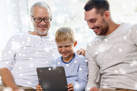 family, generation, technology and people concept - smiling father, son and grandfather sitting on...