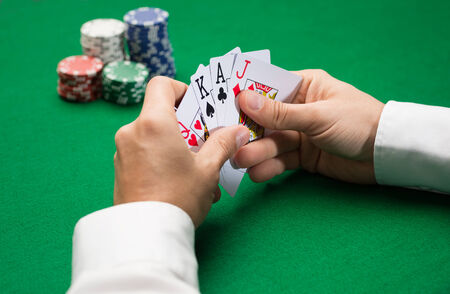 casino, gambling, poker, people and entertainment concept - close up of poker player with playing...