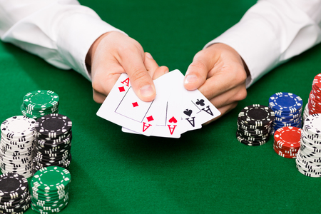 casino, gambling, poker, people and entertainment concept - close up of poker player with playing...