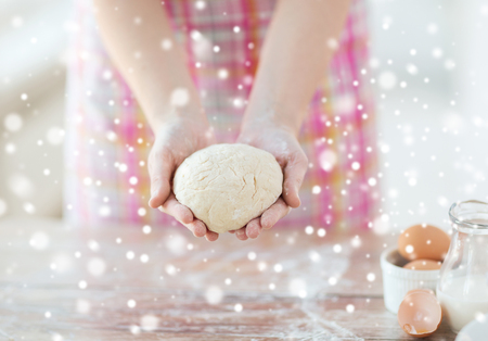 cooling and home concept - close up of female hands holding bread doughの写真素材