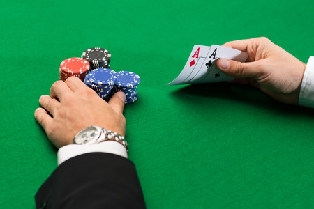 casino, gambling, poker, people and entertainment concept - close up of poker player with playing...