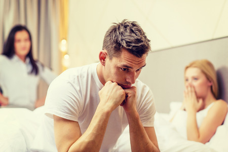 hotel, travel, relationships and sexual problems concept - wife caught man cheating with another womanの写真素材