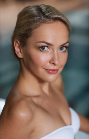 people, beauty, spa, healthy lifestyle and relaxation concept - close up of beautiful young woman in swimsuit at swimming poolの写真素材