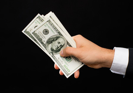 finances, people, savings and wealth concept - close up of male hands holding dollar cash money over...