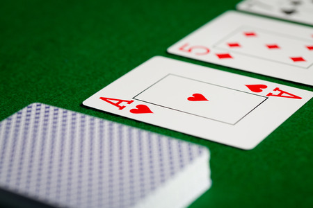 casino, gambling, poker, and entertainment concept - close up of playing cards on green table...