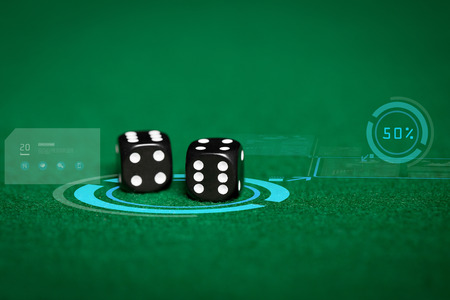 gambling, fortune, game, technology and entertainment concept - close up of black dice on green casino table and virtual projectionの写真素材