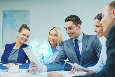 business, technology and people concept - smiling business team with tablet pc computer and virtual...