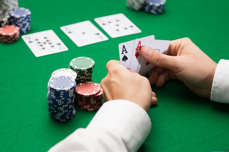casino, gambling, poker, people and entertainment concept - close up of poker player with playing...