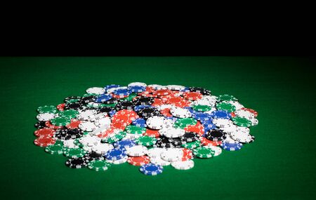 gambling, fortune, game and entertainment concept - close up of casino chips on green table surface