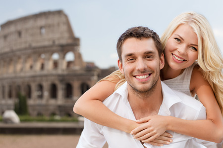 summer holidays, travel, tourism, people and dating concept - happy couple hugging over coliseum backgroundの写真素材