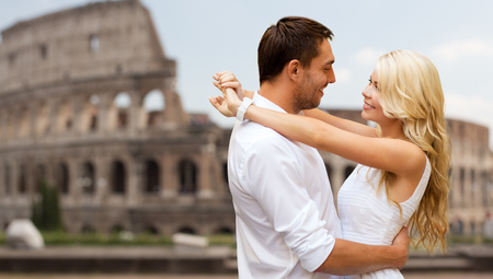 summer holidays, travel, tourism, people and dating concept - happy couple hugging over coliseum backgroundの写真素材