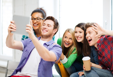 education and technology - group of students taking selfie with tablet pc at school education and technology - group of students taking selfie with tablet pc at school