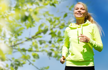 fitness, people and healthy lifestyle concept - happy young female runner jogging outdoorsの販売画像