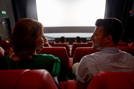 cinema, entertainment and people concept - happy friends watching movie in theater from backの写真素材