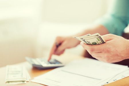 close up of man with calculator counting money and making notes at homeの写真素材