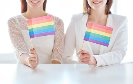 close up of happy couple holding rainbow flagsの写真素材