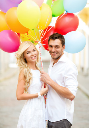 summer holidays, celebration and dating concept - couple with colorful balloons in the cityの写真素材