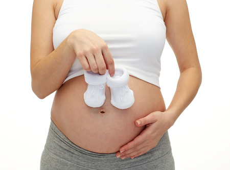 pregnancy, motherhood, people and expectation concept - close up of happy pregnant woman touching...