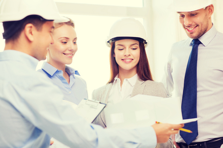 business, architecture and office concept - happy team of architects in officeの写真素材